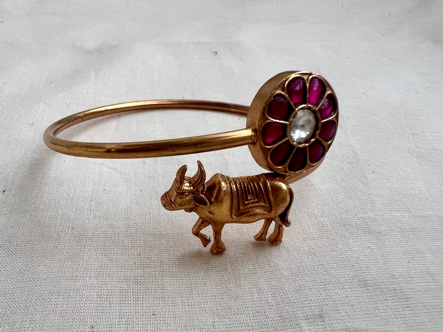 Gold polish kundan & ruby kada with cow motif